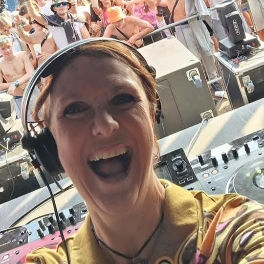 A photo of female DJ Dovetail at a festival with the crowd enjoying her set behind her
